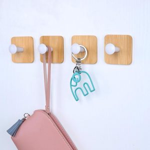 4 small white decorative heavy-duty no-nail adhesive hooks.